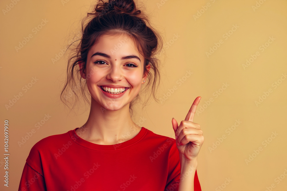 A young woman with a big smile, pointing her finger, wearing a red shirt A young woman with a big smile, pointing her finger, wearing a red shirt