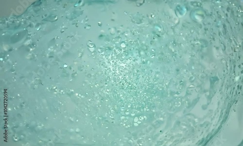 Zoom shot with micro-particle interactions in a gel: The camera starts with a view of micro-particles in a gel medium. The camera zooms in to show how the particles move and interact within the gel, i