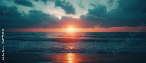 A serene sunset over the ocean, casting vibrant colors on the water and sky.