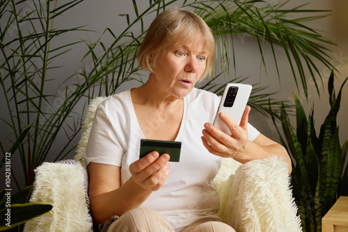 Quadro em tela Mature female shopper using smartphone for online shopping looking scared after