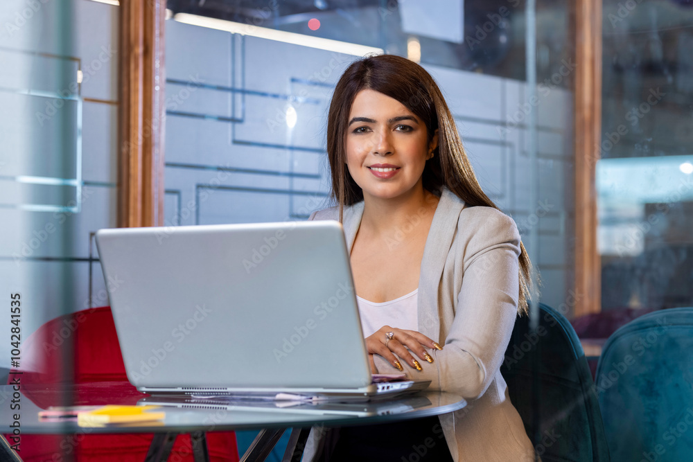 Portrait of a young businesswoman working on a laptop in an office Portrait of a young businesswoman working on a laptop in an office