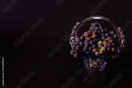 Composition of grapes in a vase on a black background, autumn ha photo