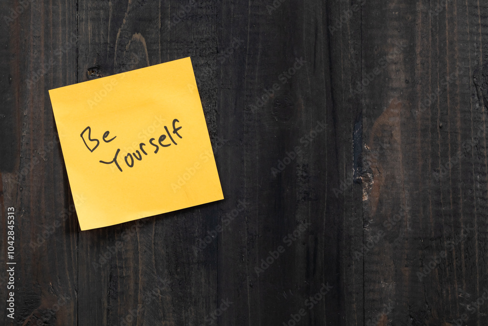 Positive idea concept image using a wooden table and a sticky note with the words Be yourself Positive idea concept image using a wooden table and a sticky note with the words Be yourself