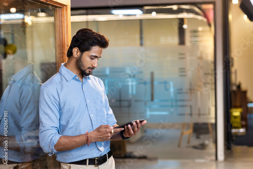 Handsome young modern businessman using digital tablet in the office photo