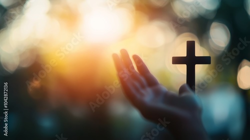 Worship God concept: Silhouette christian people hand rising over blurred cross on spiritual light background