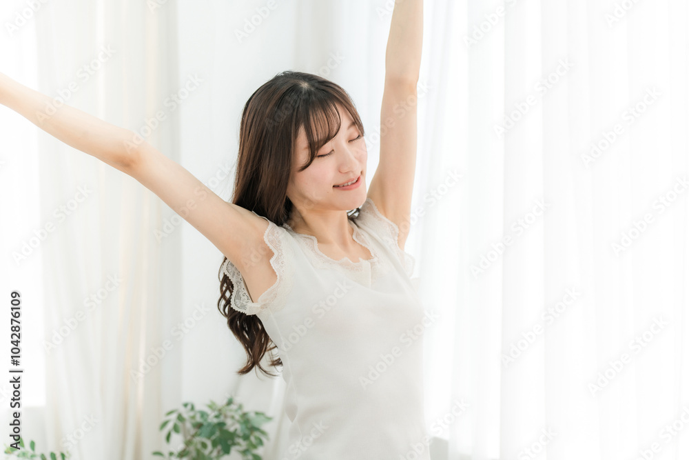 寝起き・起床時にカーテンの前で朝日を浴びる女性(深呼吸)
寝起き・起床時にカーテンの前で朝日を浴びる女性(深呼吸)