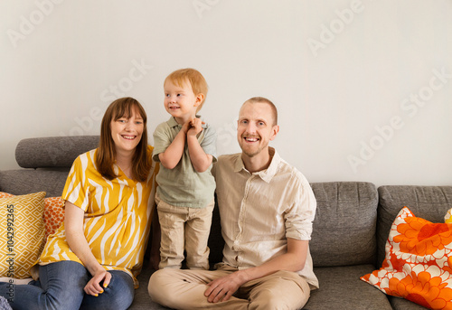 Mid adult couple with son sitting on sofa at home photo