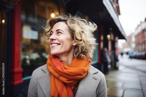 Portrait of a smiling middle aged woman with curly hair in the city