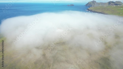 Aerial view of dense mist cover the southern remote Icelandic landmark, touristic Vestmannaeyjar