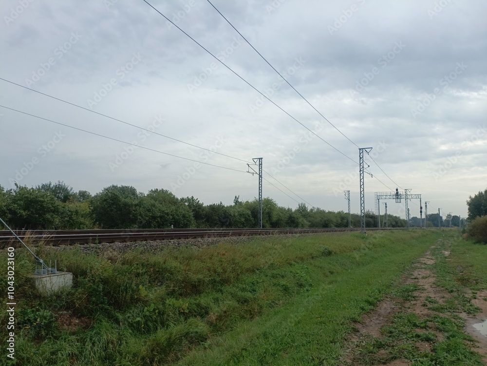 Two way railroad tracks in countryside. Two railway tracks. Cloudy day. Countryside. Fields and trees. Two way railroad tracks in countryside. Two railway tracks. Cloudy day. Countryside. Fields and trees.