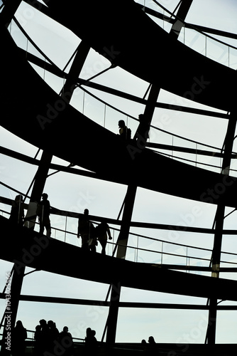 Dark people walking backlight in the shadow of an office ramp. Black people on modern building staircase. Business people walking on stairs in a workplace. Finding office job in capital city concept