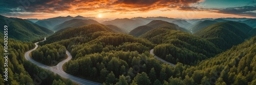 Aerial top view of mountains road in dark green forest with sky and clouds