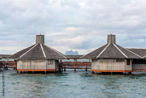 Stilted houses (floating village) with thatched roof and wooden timber walls, Bajau Sea Gypsy style accomodation in Semporna, Sabah, Malaysia (Borneo)