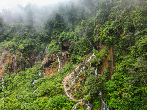 A stunning waterfall located in the center of a lush green forest