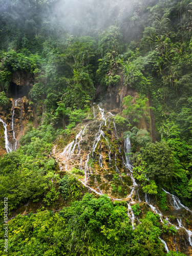 A stunning waterfall located in the center of a lush green forest
