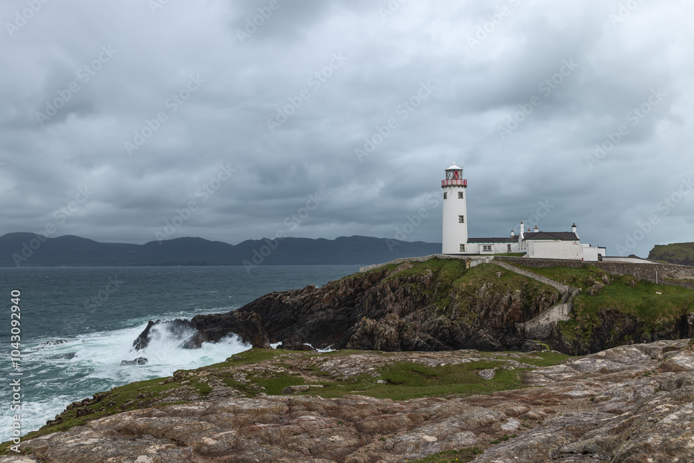 Stormy weather at Fanad Head Lighthouse in Ireland, with powerful ocean waves and winds crashing against the rugged coastline Stormy weather at Fanad Head Lighthouse in Ireland, with powerful ocean waves and winds crashing against the rugged coastline