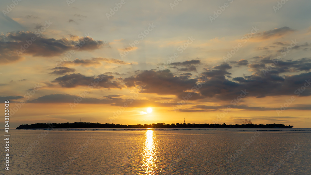 Fototapeta premium the sun is setting over a small island in the middle of the ocean
