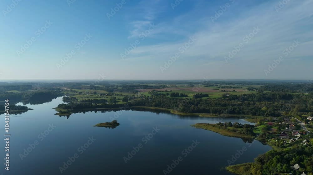 4K. A serene aerial view of a calm Dagda lake, lush green Latgale fields, and rural houses, showcasing the peaceful beauty of the Latvian countryside. 4K. A serene aerial view of a calm Dagda lake, lush green Latgale fields, and rural houses, showcasing the peaceful beauty of the Latvian countryside.