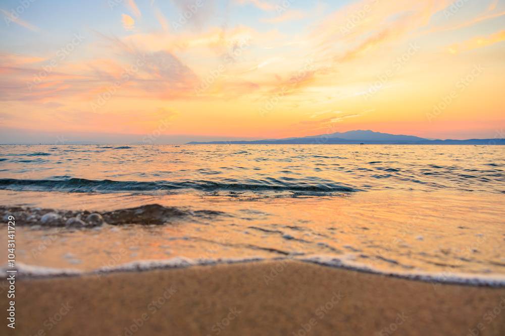 Obraz premium The ocean is calm and the sky is a beautiful orange color