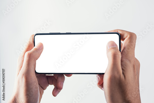 Hand holding mobile phone with white blank screen mockup for playing game screen
