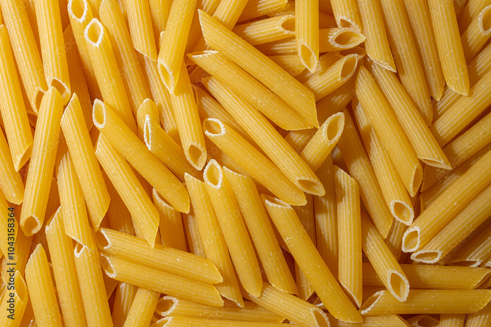 Uncooked Penne Rigate Pasta: A Culinary Canvas of Penne Macaroni, Creating a Lively and Textured Background for Gourmet Cooking. Dry Pasta. Raw Macaroni - Top View, Flat Lay Uncooked Penne Rigate Pasta: A Culinary Canvas of Penne Macaroni, Creating a Lively and Textured Background for Gourmet Cooking. Dry Pasta. Raw Macaroni - Top View, Flat Lay