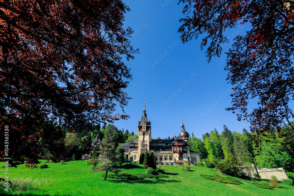Obraz premium Exploring Peles Castle surrounded by lush greenery on a sunny day in Romania