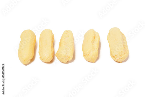 Neatly stacked mini cream puffs (sus kering) in a thumb-sized, golden-yellow shape. Photographed on a white background. Perfect as a light snack. photo