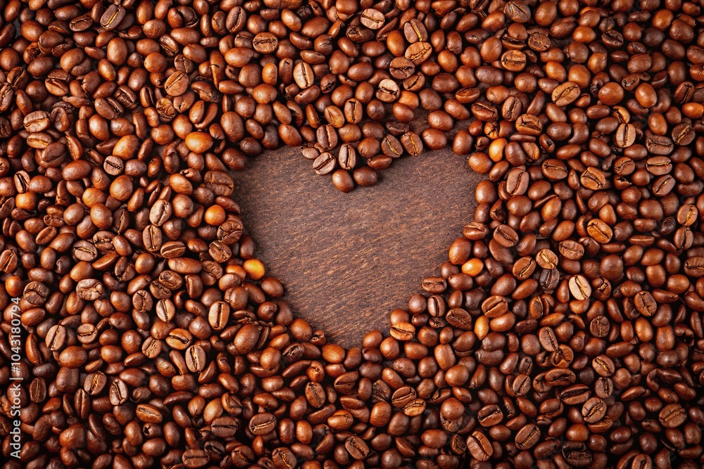 Heart shaped coffee beans in a frame with roasted beans forming a heart, captured at a tilted angle Heart shaped coffee beans in a frame with roasted beans forming a heart, captured at a tilted angle