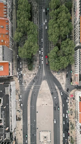 Vertical drone footage of a Lisbon avenue leading to the Monumento dos Restauradores, showcasing the urban landscape and historic monument. Portugal travel destination