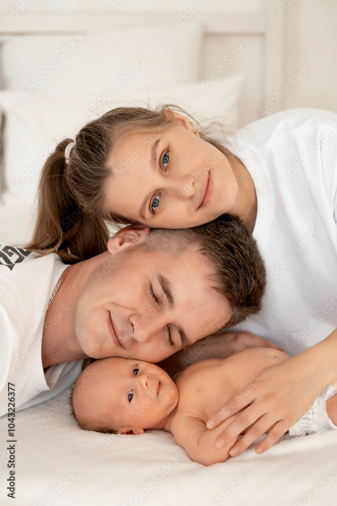 portrait of a happy family with a newborn baby close-up, mom, dad and baby at home on the bed. portrait of a happy family with a newborn baby close-up, mom, dad and baby at home on the bed.