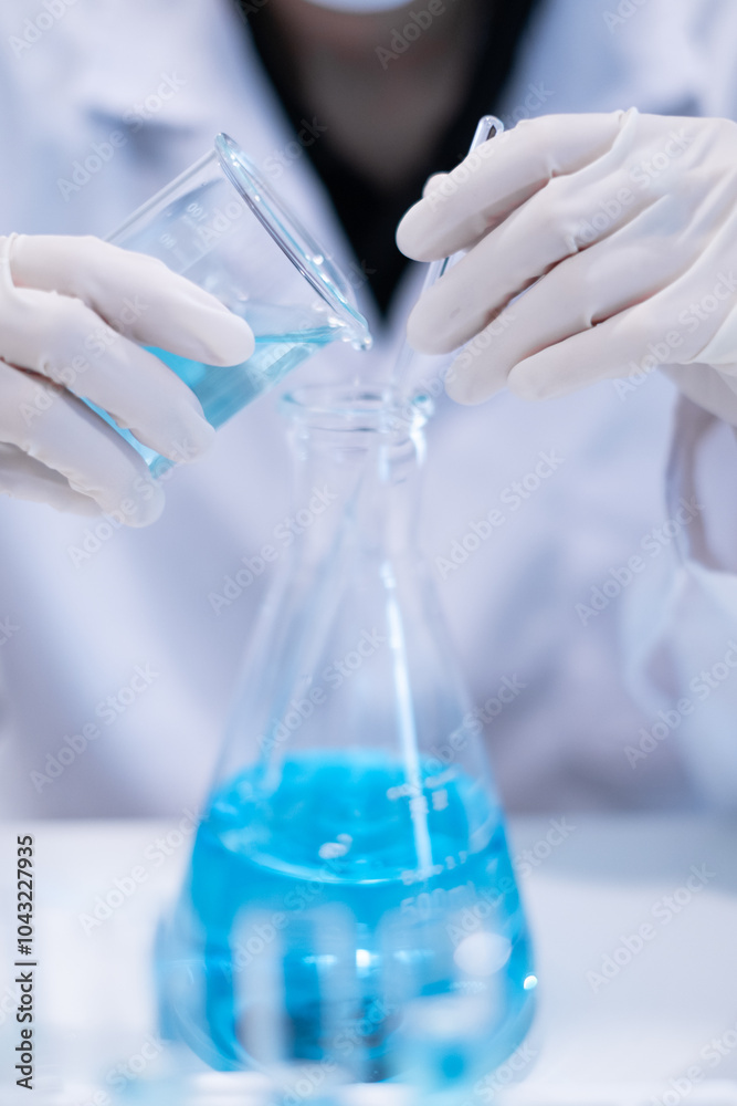 Close-up scientist pouring blue liquid into test tube beaker flask equipment pipette working laboratory experiment research chemical biology discovery healthcare and medicine accuracy solution Close-up scientist pouring blue liquid into test tube beaker flask equipment pipette working laboratory experiment research chemical biology discovery healthcare and medicine accuracy solution