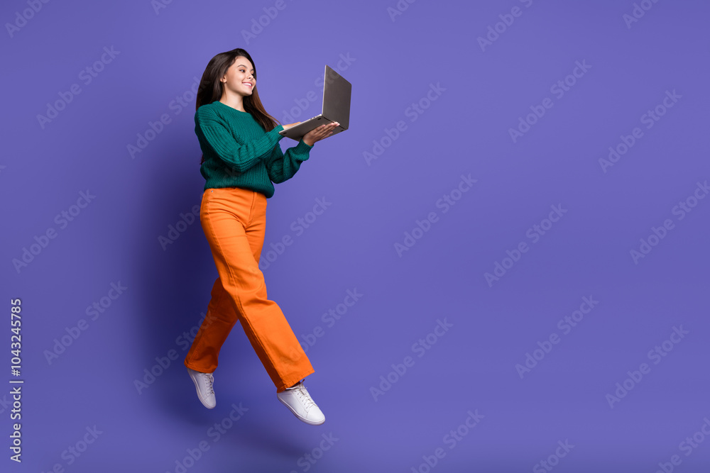 Full length portrait of nice young girl jump laptop empty space isolated on violet color background Full length portrait of nice young girl jump laptop empty space isolated on violet color background