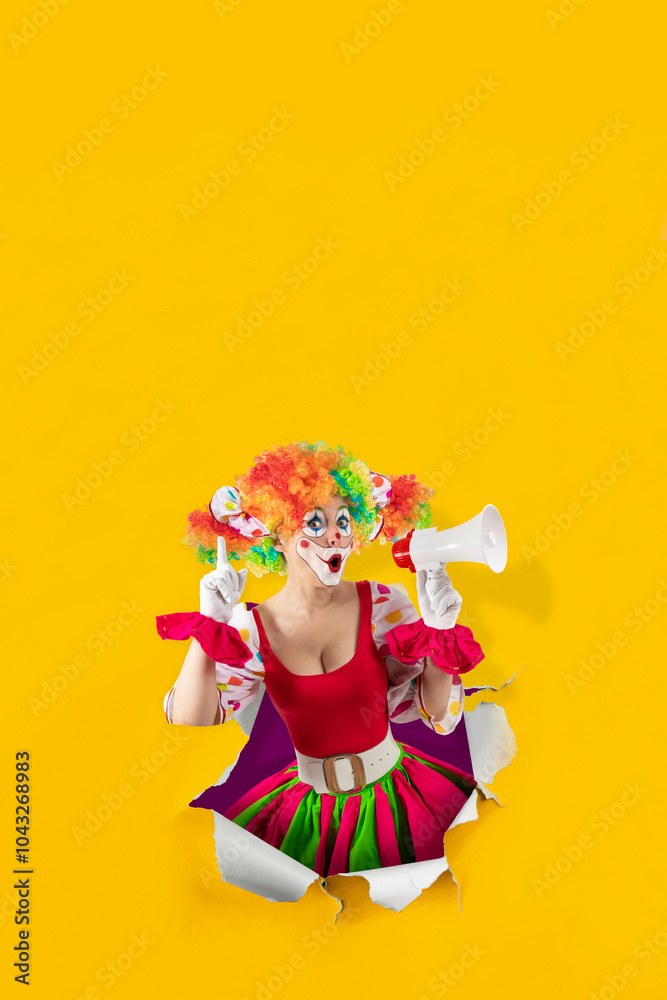 Funny female clown shouting with loudspeaker pointing finger up, looking through the ripped paper hole. Woman entertainer as colorful Joker, suit and wig, clown whiteface makeup, professional actor. Funny female clown shouting with loudspeaker pointing finger up, looking through the ripped paper hole. Woman entertainer as colorful Joker, suit and wig, clown whiteface makeup, professional actor.