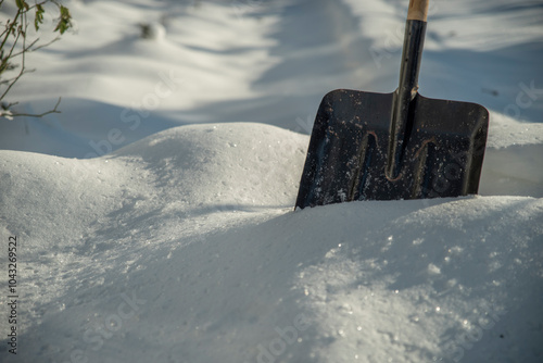 Snow shovel stuck in a snowdrift. Forecast concept.