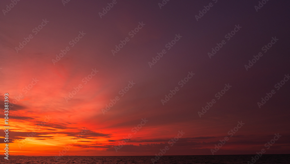 Fototapeta premium Dusk, Sunset sky clouds over sea in the evening on twilight with dark Blue, Purple, Pink, Red and Orange sunlight, Horizon sea sky sun down landscape backgrounds in Autumn