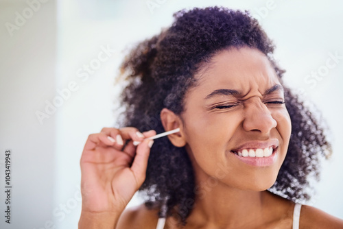 Scared, woman and cotton swab for hygiene with eyes closed for self care and cleaning. African person, home and removing earwax for germs, dirt and bacteria for wellness, routine and grooming photo