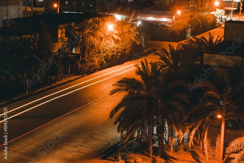 Evening street scene with illuminated buildings and palm trees. Bandar-e Mahshahr, Iran photo