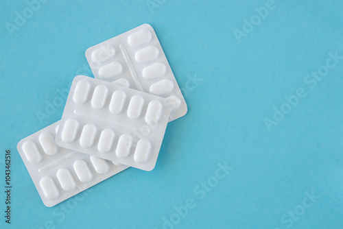 Tabletten or pillen in white package on the blue background with place for text.