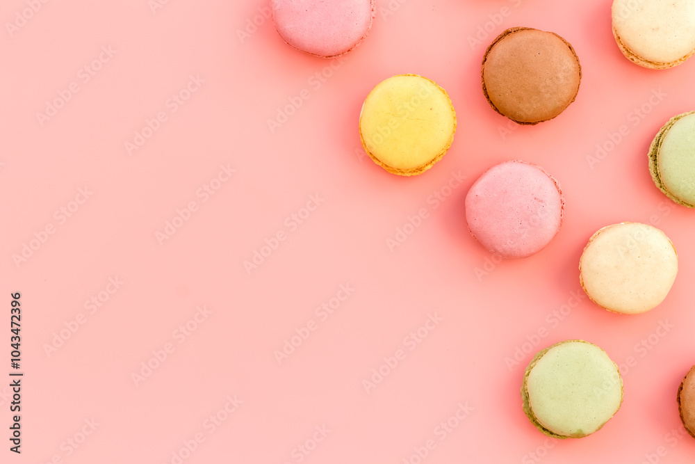 Fototapeta premium Brignt macarons for sweet break on pink background top view mock up