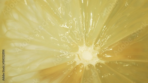 Fotografie The macro photography of a sliced fresh lemon with vibrant yellow color and visible in the juicy flesh of the citrus fruit