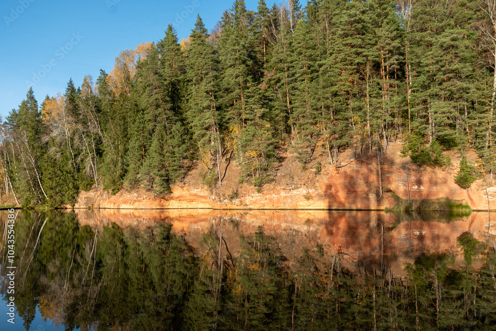 sandstone outcrops on the bank of Brasla river, colorful trees in autumn, bright colors, Latvia sandstone outcrops on the bank of Brasla river, colorful trees in autumn, bright colors, Latvia