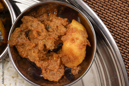 Bengali style beef chicken mutton lamb meat with potato curry side dish in small metal stainless steel bowl photo