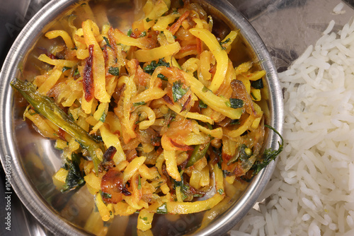 Bengali style sautéed potato with onion alu bhaji baji side dish in small metal stainless steel bowl photo