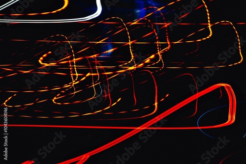 The image is a blurry, colorful, and dynamic representation of a car's headlights. The streaks of light create a sense of motion and energy, evoking a feeling of excitement and movement