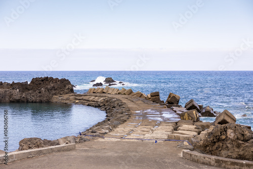 View of the natural pool and Atlantic Ocean separated by a pier in Seixal. Madeira Island, Portugal photo