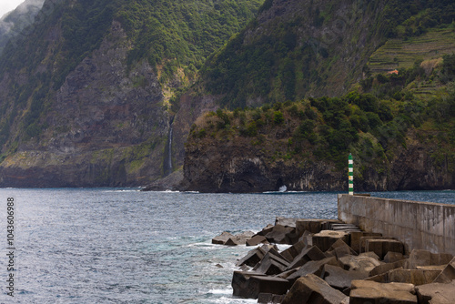 Coastline with big cliffs of Seixal and the Port with the Veu da Noiva waterfall in the background. Madeira island, Portugal photo