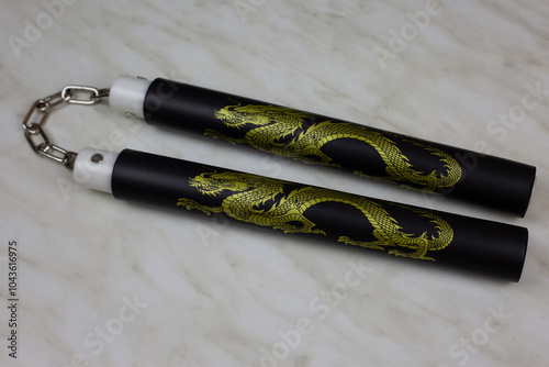 Training nunchucks made of soft material on white background, oriental inertial edged weapons of impact, shock-crushing and suffocating action, foam rubber training nunchucks photo