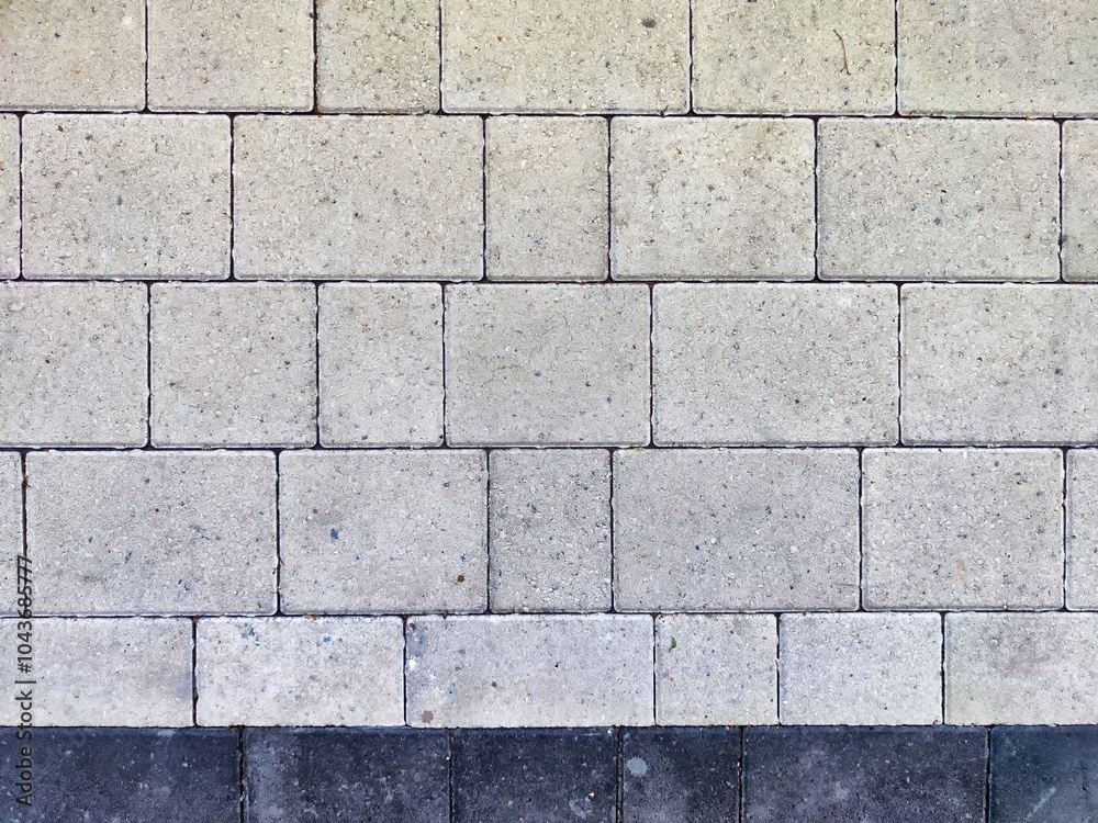 Gray square pavement blocks arranged in a neat pattern in an outdoor area Gray square pavement blocks arranged in a neat pattern in an outdoor area