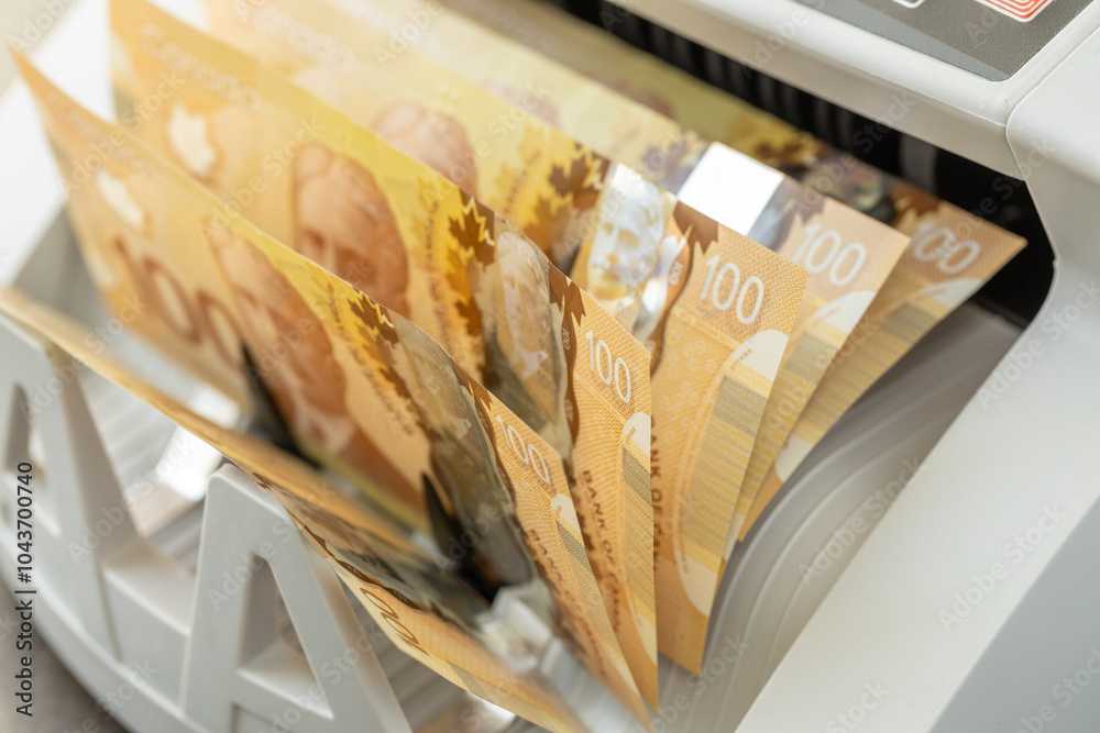 Canadian dollars counted in cash counting machine. Finance business concept. Canada money, close up
