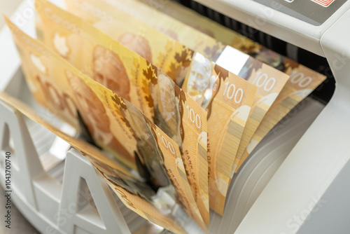 Obraz na płótnie Canadian dollars counted in cash counting machine. Finance business concept. Canada money, close up w salonie